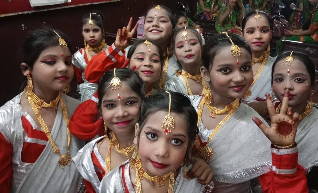Girls in traditional dance attire performing on stage